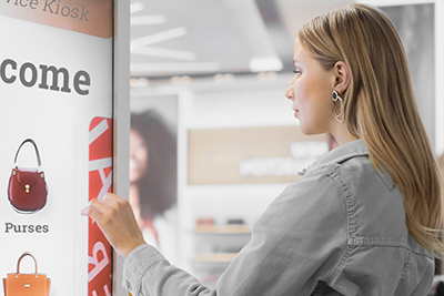 Beautiful Female Customer Using Floor-Standing LCD Touch Display